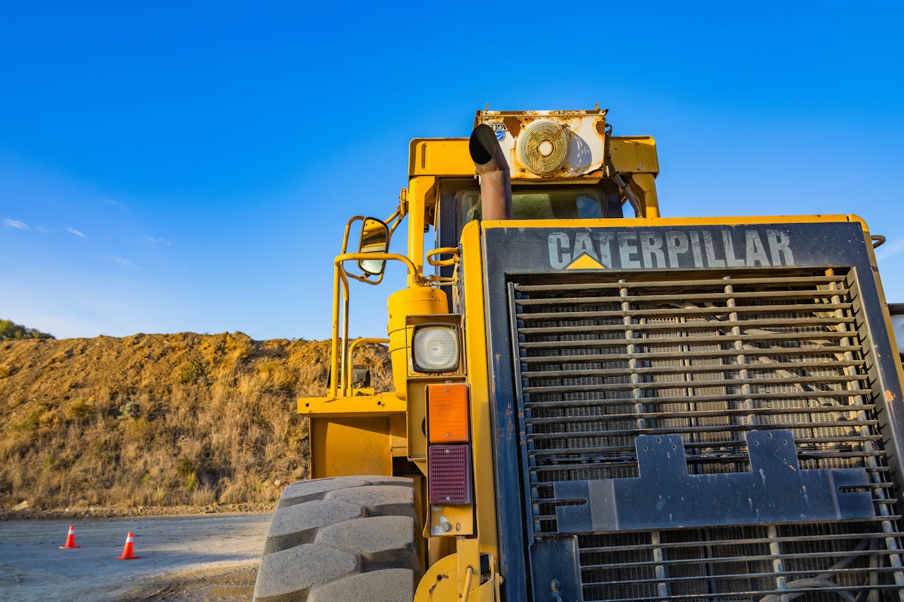 Front view of a large Caterpillar bulldozer outdoors on a construction site under clear blue skies.